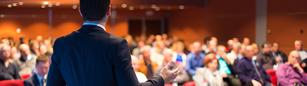Person speaking to large group Person speaking to large group