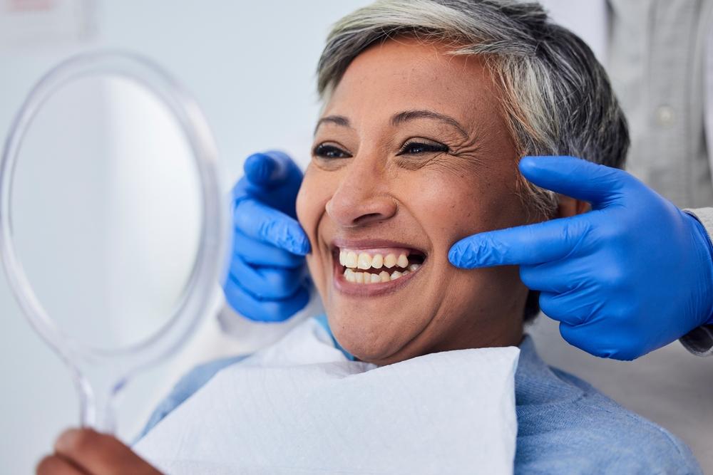 Woman looking in the mirror at the dentist